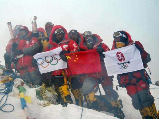 2008年5月8日,北京奥运圣火珠峰传递登山队收效登顶珠峰,中国登山队员在峰顶展示中国国旗、奥运五环旗和北京奥运会会徽旗。新华社发